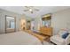 Spacious main bedroom with wood floors, ceiling fan, a comfy chair, and lots of mirrors at 6365 Jim Davis Rd, Parrish, FL 34219