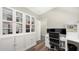 Bright office with built-in shelving, glass door cabinets, wood floors, and modern black office chair at 6365 Jim Davis Rd, Parrish, FL 34219