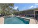 Relaxing backyard featuring a sparkling pool, jacuzzi, and screened patio area with comfortable lounge seating at 6365 Jim Davis Rd, Parrish, FL 34219