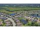 An aerial view highlights houses near a pond in a residential community with lush landscaping at 6412 Golden Eye Gln, Lakewood Ranch, FL 34202