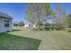 Spacious backyard featuring a well-maintained lawn, mature trees, and a serene pond view at 6412 Golden Eye Gln, Lakewood Ranch, FL 34202