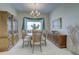 Dining room featuring a chandelier, window with decor, and wood furniture at 6412 Golden Eye Gln, Lakewood Ranch, FL 34202