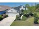 Aerial view of a lovely home showcasing a lush lawn, paved driveway, and a two-car garage at 6412 Golden Eye Gln, Lakewood Ranch, FL 34202