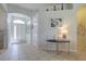 Bright foyer featuring tile flooring, a glass table, arched doorway, and a view of the front door with transom window at 6412 Golden Eye Gln, Lakewood Ranch, FL 34202