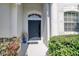 Charming front entrance with a blue door, manicured landscaping, and an inviting pathway at 6412 Golden Eye Gln, Lakewood Ranch, FL 34202