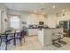 Well-lit kitchen with white cabinets, tile floors, breakfast bar, and adjacent dining area at 6412 Golden Eye Gln, Lakewood Ranch, FL 34202