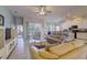 Spacious living room with tile floors, neutral sofas, ceiling fan, and a partial view of the kitchen with white cabinets at 6412 Golden Eye Gln, Lakewood Ranch, FL 34202