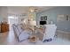 Open-concept living room with tile flooring, neutral furniture, ceiling fan, and an arched doorway leading to the foyer at 6412 Golden Eye Gln, Lakewood Ranch, FL 34202