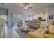 Open-plan living area with tile flooring, comfortable seating, a view of the kitchen, and sliding doors to the lanai at 6412 Golden Eye Gln, Lakewood Ranch, FL 34202