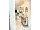 Hallway leading to living room with tile floors, decorative mirror cabinet, and ample natural light at 6442 Barberry Ct, Lakewood Ranch, FL 34202