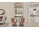 Stylish bar area adjacent to dining room and kitchen with dark counters and stools at 7011 Portmarnock Pl, Lakewood Ranch, FL 34202
