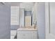 Stylish bathroom with a single sink vanity, large mirror, and patterned wallpaper at 7011 Portmarnock Pl, Lakewood Ranch, FL 34202