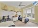 Bright bedroom featuring twin beds, nautical decor, and a ceiling fan at 7011 Portmarnock Pl, Lakewood Ranch, FL 34202