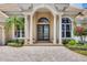 Inviting entryway showcasing double doors, columns and manicured landscaping at 7011 Portmarnock Pl, Lakewood Ranch, FL 34202
