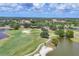 A lush golf course features ponds and sand traps amid stunning landscapes, as seen from an aerial view at 7011 Portmarnock Pl, Lakewood Ranch, FL 34202