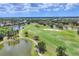 Aerial view of a lush green golf course with sand traps, ponds, and meticulously manicured fairways at 7011 Portmarnock Pl, Lakewood Ranch, FL 34202