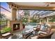 Outdoor lanai featuring a fireplace, wicker furniture, and view of the pool at 7011 Portmarnock Pl, Lakewood Ranch, FL 34202