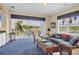 Cozy living room with blue carpeting, comfortable seating, and a view of the outdoor patio and golf course at 7011 Portmarnock Pl, Lakewood Ranch, FL 34202
