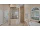 Beautiful bathroom features a soaking tub, shower, and travertine tile at 7011 Portmarnock Pl, Lakewood Ranch, FL 34202