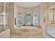 Luxurious main bathroom features a large soaking tub, shower, and travertine tile at 7011 Portmarnock Pl, Lakewood Ranch, FL 34202