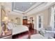 Spacious main bedroom with a tray ceiling, hardwood floors, and a private sitting area at 7011 Portmarnock Pl, Lakewood Ranch, FL 34202