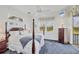 Bright bedroom featuring a four-poster bed, ceiling fan, and scenic outdoor views at 7011 Portmarnock Pl, Lakewood Ranch, FL 34202