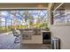 An outdoor kitchen with stainless steel appliances and a bar area, perfect for enjoying a meal al fresco at 7011 Portmarnock Pl, Lakewood Ranch, FL 34202