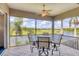 Serene screened patio with table and chairs overlooking a pond, golf course, and tropical palm trees at 7011 Portmarnock Pl, Lakewood Ranch, FL 34202
