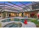 A stunning screened-in pool and spa with beautiful pavers and an outdoor kitchen, perfect for entertaining at 7011 Portmarnock Pl, Lakewood Ranch, FL 34202