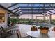 Beautiful pool area with a screened enclosure, lush landscaping, and outdoor seating at 7011 Portmarnock Pl, Lakewood Ranch, FL 34202