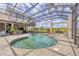 Gorgeous pool featuring a screened enclosure, lush landscaping, and an attached spa at 7011 Portmarnock Pl, Lakewood Ranch, FL 34202