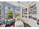 Bright sitting room featuring custom bookshelves, comfortable lounge, and large windows at 7011 Portmarnock Pl, Lakewood Ranch, FL 34202