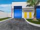 Exterior of the business featuring large blue doors, yellow doors, and palm tree landscaping at 8100 Ciboney Ct # 11, Sarasota, FL 34240