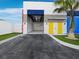 Commercial exterior with large bay door, yellow doors, and manicured landscaping at 8100 Ciboney Ct # 11, Sarasota, FL 34240