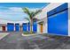 Exterior shot displaying blue doors and a modern design, along with green space and a well-kept parking area at 8100 Ciboney Ct # 11, Sarasota, FL 34240