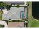Aerial view showcasing a house with a screened pool and well-maintained landscaping near a waterfront at 8715 52Nd E Ave, Bradenton, FL 34211