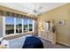 Bright bedroom featuring a ceiling fan, large windows with a golf course view, and a dresser with a mirror at 8715 52Nd E Ave, Bradenton, FL 34211