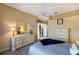 This bedroom has neutral walls, ceiling fan, dresser with mirror, and a glimpse of the outdoors through the glass door at 8715 52Nd E Ave, Bradenton, FL 34211