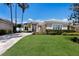 Attractive home front exterior showcasing a paver driveway, lush green lawn, and meticulously maintained shrubbery at 8715 52Nd E Ave, Bradenton, FL 34211