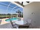 Outdoor seating next to a screened in pool with a view of a pond and the golf course at 8715 52Nd E Ave, Bradenton, FL 34211