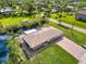 Aerial view of home with brick paved driveway, screened in lanai, and water views at 9080 Caloosa Dr, Venice, FL 34293