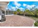 Spacious brick patio and backyard with screened lanai, perfect for entertaining and enjoying the outdoors at 9080 Caloosa Dr, Venice, FL 34293