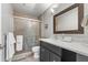 Bathroom with a glass shower, modern sink, and sleek vanity with grey accents at 9080 Caloosa Dr, Venice, FL 34293