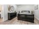Bedroom with a black dresser, a black bed, and light-colored wood-look floors at 9080 Caloosa Dr, Venice, FL 34293