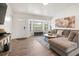 Inviting living room featuring wood flooring, a cozy sectional sofa, and natural light at 9080 Caloosa Dr, Venice, FL 34293