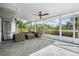 Relaxing screened lanai features wicker furniture and ceiling fan, offering a comfortable outdoor living space at 9080 Caloosa Dr, Venice, FL 34293