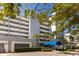 View of front entrance of the condos with palm trees and blue awning at 1000 Riverside Dr # B501, Palmetto, FL 34221