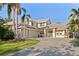 A charming two-story home with a well-manicured lawn, palm trees, and a wide driveway at 1016 91St Nw St, Bradenton, FL 34209