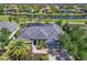 An aerial view showcases the tile roof, and the surrounding water features and lush landscaping in this waterfront community at 10411 Winding Stream Way, Bradenton, FL 34212