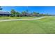 Expansive backyard with lush green grass, a paved path, and views of neighboring homes and manicured landscaping at 10411 Winding Stream Way, Bradenton, FL 34212
